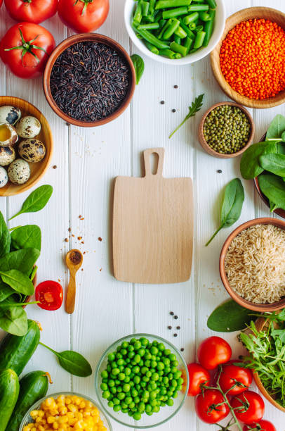 istock Wooden cutting board surrounded by fresh vegetables, groats 1215211629