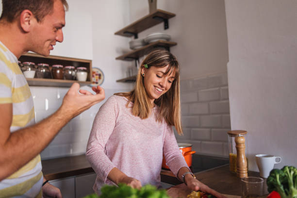 istock Husband and wife talking during dinner preparation 1215214505
