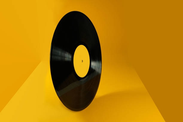 istock Vinyl record on an abstract yellow background. Old vintage vinyl record. 1215219247