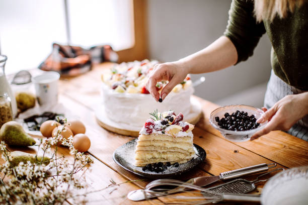 istock Woman Decorating Cake With Lemon, Lime And Strawberries 1215219861