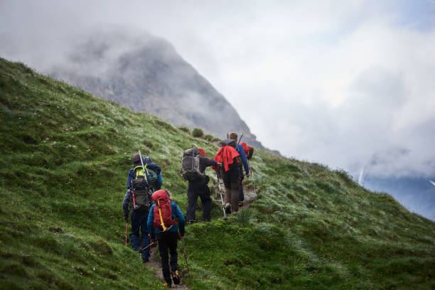 istock Group of tourists walking uphill in mountains. 1215221519