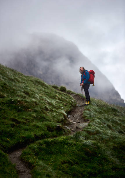 istock Male hiker standing on grassy hill. 1215221528