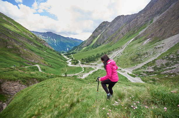 istock Female hiker walking down the grassy hill. 1215221538
