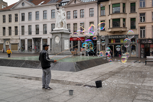 Ghent/Belgium - October 10, 2019: Man doing People Big soap bubbles in central plaza of Ghent, the capital of the East Flanders province in Belgium.