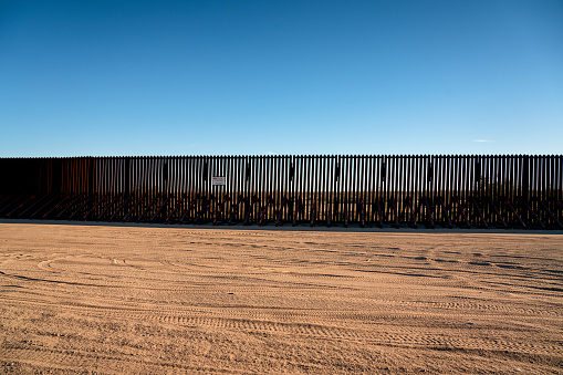 The International Border Barrier along the California state line and Mexico as the sun is setting