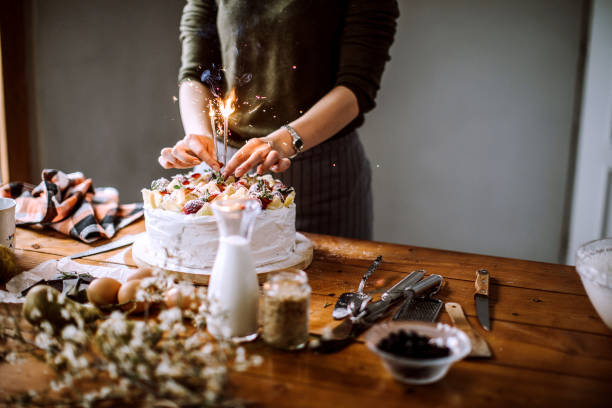 istock Woman Adding Sprinkles to Delicious Birthday Cake 1215223838