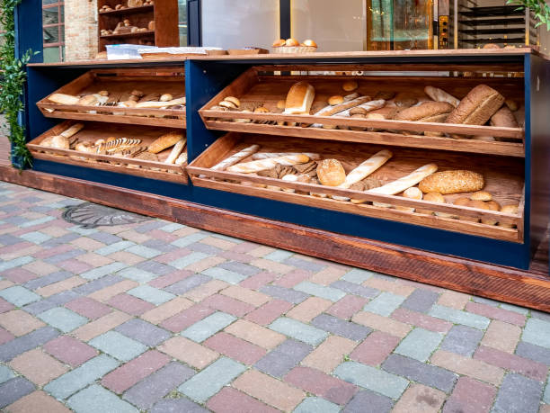 Batch of fresh baked buns and loafs on a market counter, ctotal absence of people near the counter