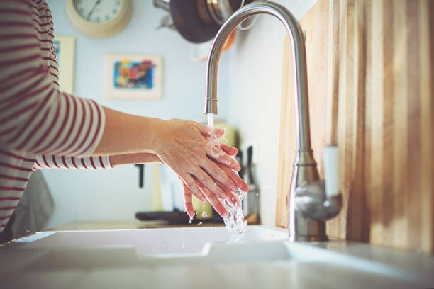 istock Woman washes her hands with soap at the sink 1215225812