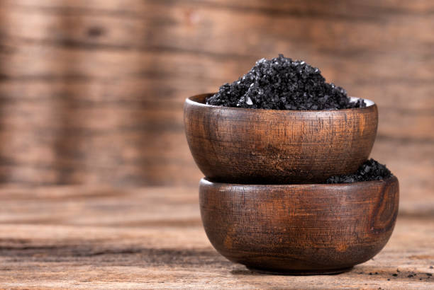 istock Hawaiian black salt in wooden bowls - text space 1215226256
