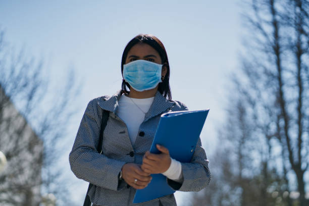 istock Girl putting on a protective mask to avoid contagion while walking down the street. Coronavirus concept 1215226918