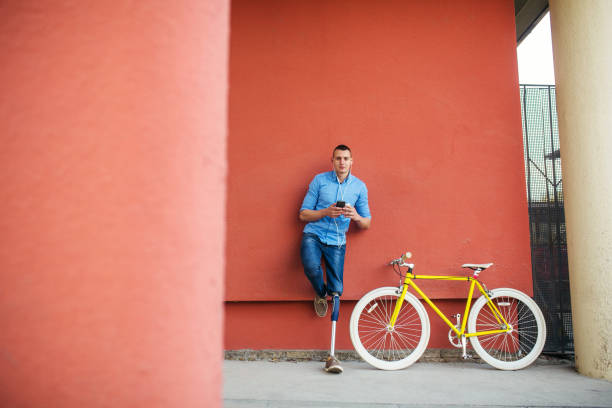 istock Young male with prosthetic leg standing next to bicycle 1215228031