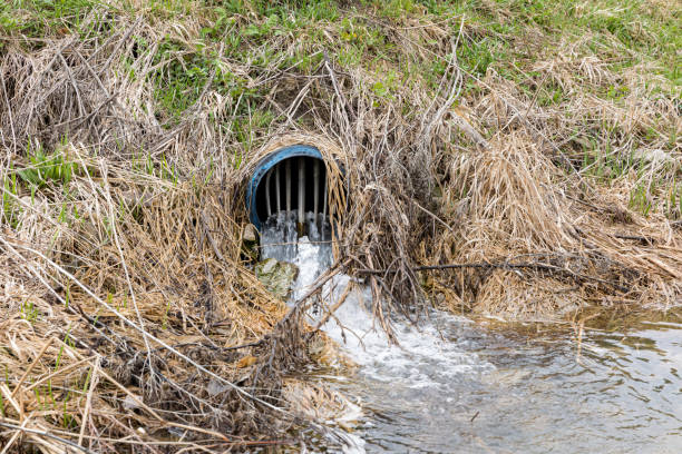 água que flui da saída de ladrilhos de campo agrícola após tempestades de primavera e chuvas fortes criaram inundações - controla da erosão - fotografias e filmes do acervo