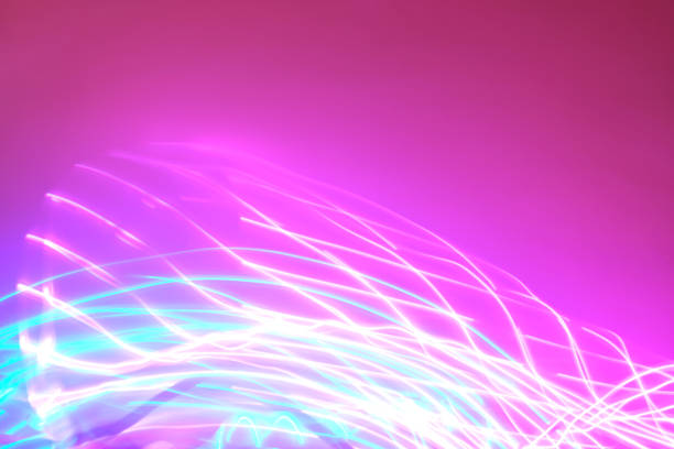 istock Abstract background of neon lights in motion on pink backdrop. 1215236699