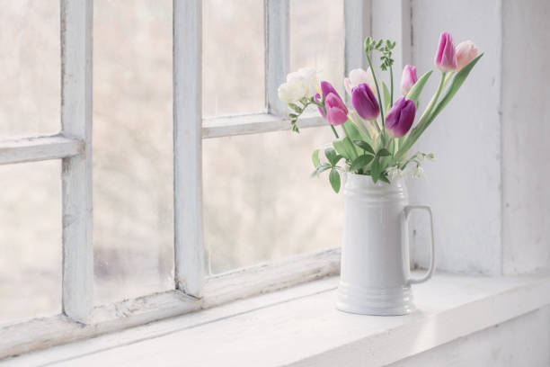 istock beautiful tulips on old white windowsill 1215236721