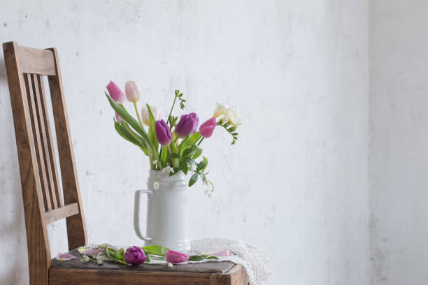 istock spring flowers on old chair on background old white wall 1215236724