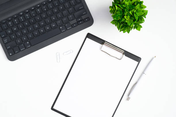 istock Top view office table desk with laptop computer, paper clipboard, green plant. Modern minimal workspace concept 1215237933