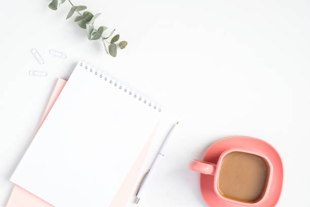 istock Stylish woman's workspace with paper notebook and pink coffee cup. Modern minimal style feminine home office desk concept 1215238049
