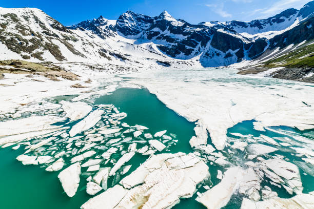 derretimento do lago serru entre a paisagem alpina - gran paradiso, itália - melting spring snow trentino alto adige - fotografias e filmes do acervo