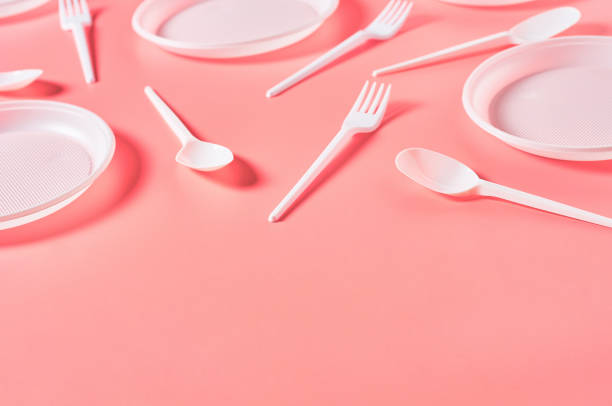 istock Disposable plastic utensils scattered on pink background. Concept of save environment, ecology, recreation on picnic, party and other events. Copy space 1215246741