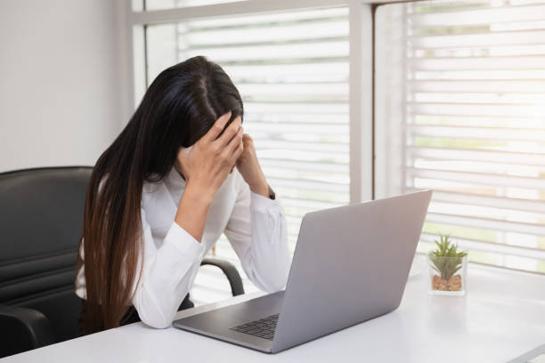 istock Business Woman Having Headache While Working Using Laptop Computer. Stressed And Depressed Girl Touching Her Head, Feeling Pain While Sitting At Wooden Tabl, Work Failure Concept 1215252129