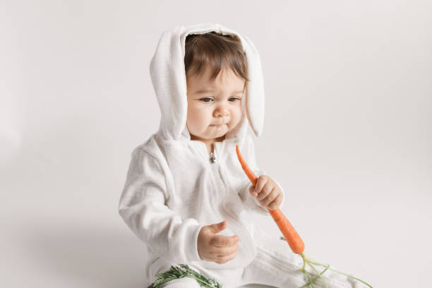 weißes baby girl bunny mit frischen karotten - bunny girl stock-fotos und bilder