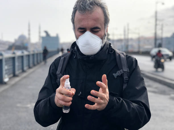 Man disinfecting his hands due to coronavirus risk