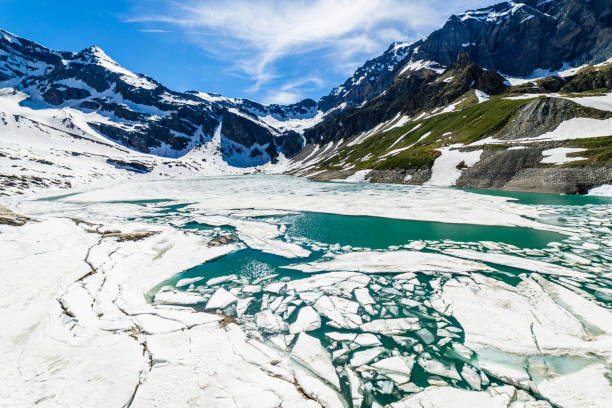 derretimento do lago serru entre a paisagem alpina - gran paradiso, itália - melting spring snow trentino alto adige - fotografias e filmes do acervo