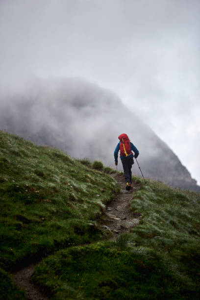 istock Male hiker walking uphill in mountains. 1215255500