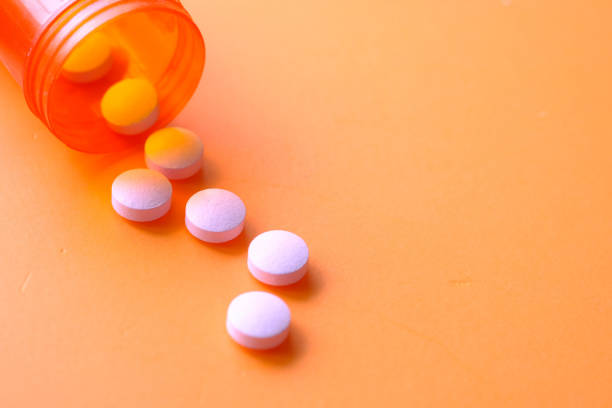 istock pink color pills spilling from container , close up 1215256132