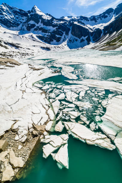 derretimento do lago serru entre a paisagem alpina - gran paradiso, itália - melting spring snow trentino alto adige - fotografias e filmes do acervo