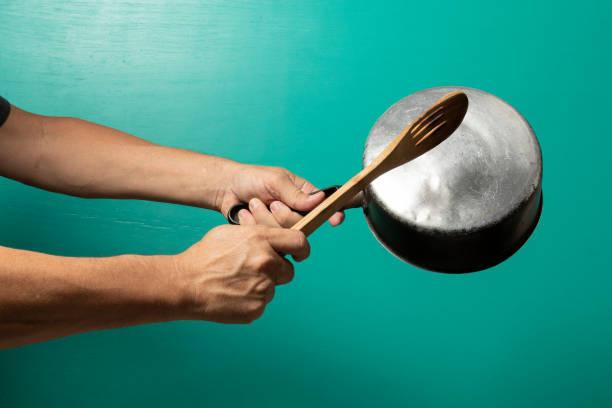 person hitting pot to protest, with a green background. manifestante, crisis, social, activista, empoderamiento, revolución, estudiantes, política, protesta, símbolo, salteado, olla, cuchara, caceroa, cocina, utensilios de cocina, sartén, utensilios, conjunto, caricatura, utensilios de cocina, equipo, cazue