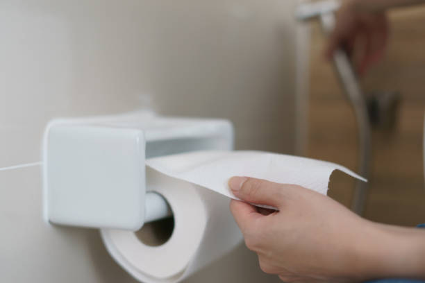 istock Hand pulling a roll of toilet paper tissue. 1215261647
