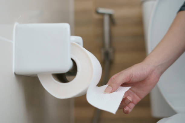 istock Hand pulling a roll of toilet paper tissue. 1215261665