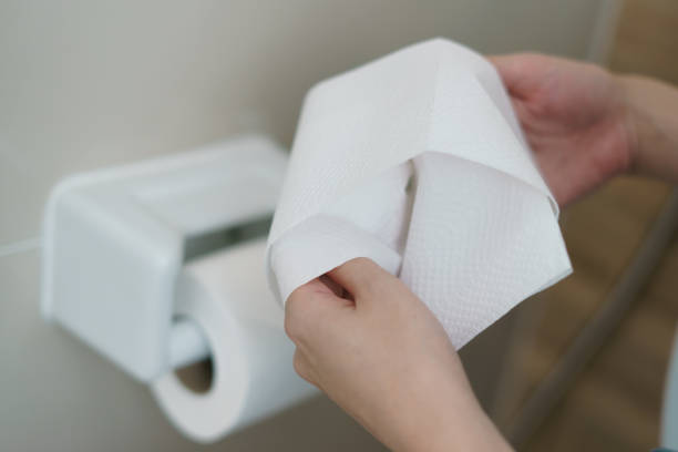 istock Hand pulling a roll of toilet paper tissue. 1215261700