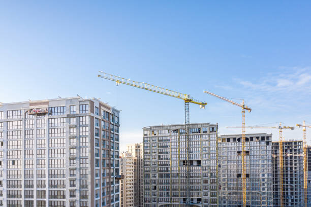 istock construction site with high-rise buildings and cranes on blue sky background. aerial view 1215261812