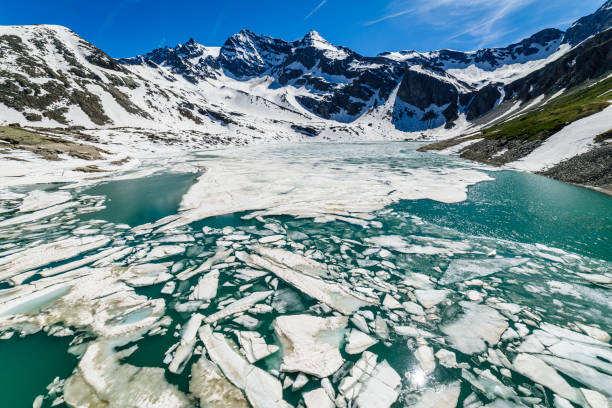 derretimento do lago serru entre a paisagem alpina - gran paradiso, itália - melting spring snow trentino alto adige - fotografias e filmes do acervo