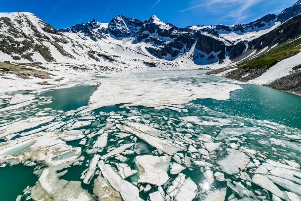 таяние озера серру между альпийским ландшафтом - гран парадизо, италия - melting spring snow trentino alto adige стоковые фото и изображения