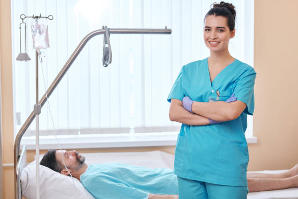 istock Young nurse at patients bed 1215265912