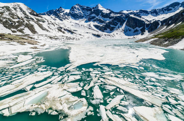 derretimento do lago serru entre a paisagem alpina - gran paradiso, itália - melting spring snow trentino alto adige - fotografias e filmes do acervo