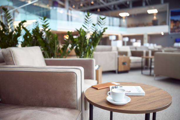 Cappuccino, book and wallet on table at departure lounge