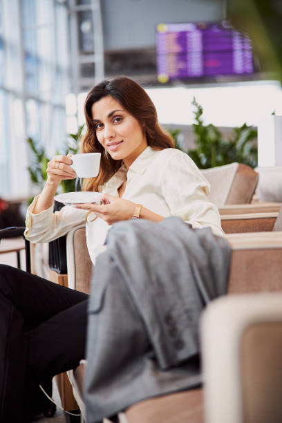 istock Pretty lady drinking coffee in departure lounge 1215266760