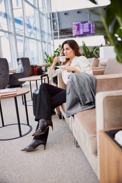 istock Elegant lady drinking coffee in departure lounge 1215266761