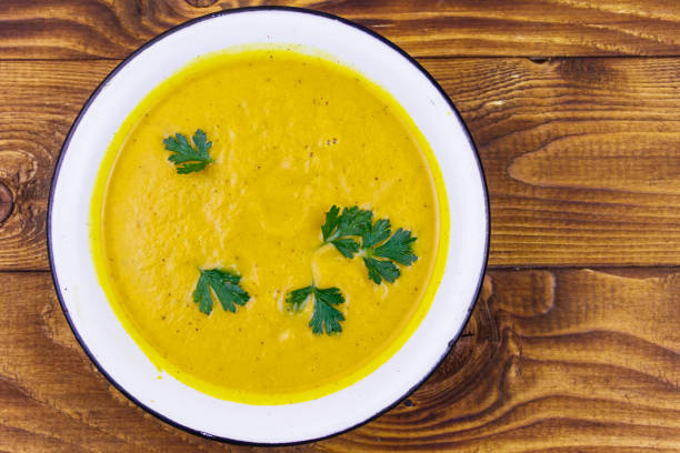 istock Pumpkin soup on a wooden table. Top view 1215266824