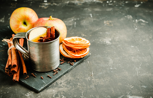 Apple cider in metal mug ont rustic background