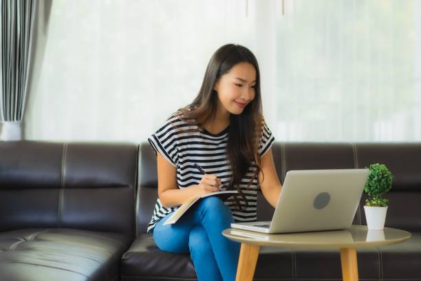 istock Portrait beautiful young asian woman using laptop or computer noterbook on sofa with concept work from home 1215269439