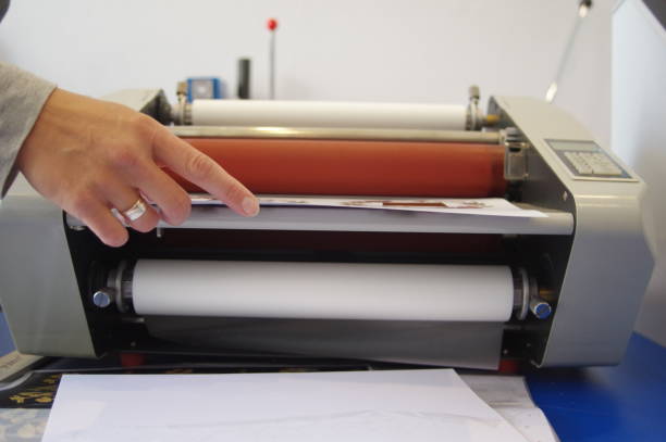 la imagen de una máquina laminadora - laminated plastic printout paper industry fotografías e imágenes de stock