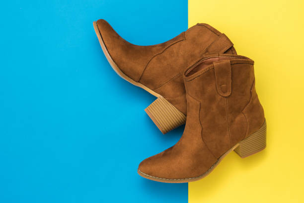 istock Suede boots with high heels on a yellow and blue background. 1215269496