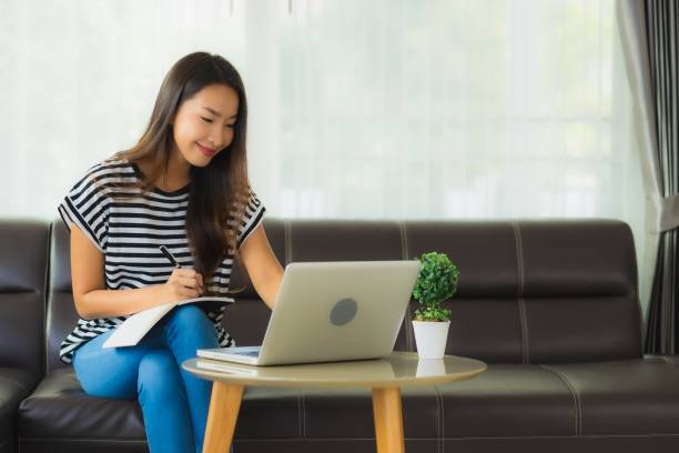 istock Portrait beautiful young asian woman using laptop or computer noterbook on sofa with concept work from home 1215269536