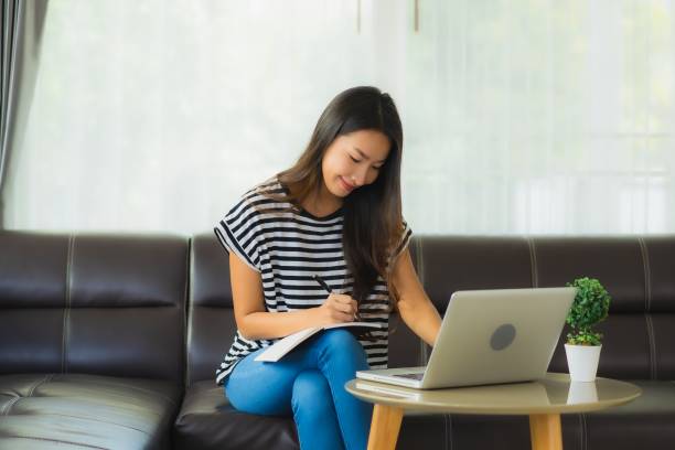 istock Portrait beautiful young asian woman using laptop or computer noterbook on sofa with concept work from home 1215269568