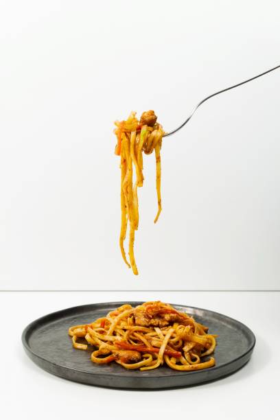 istock Pasta bolognese on black plate with fork. 1215271955